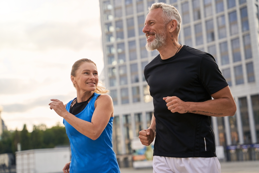 Portrait,Of,Active,Middle,Aged,Couple,,Man,And,Woman,In a middle-aged couple running together and smiling